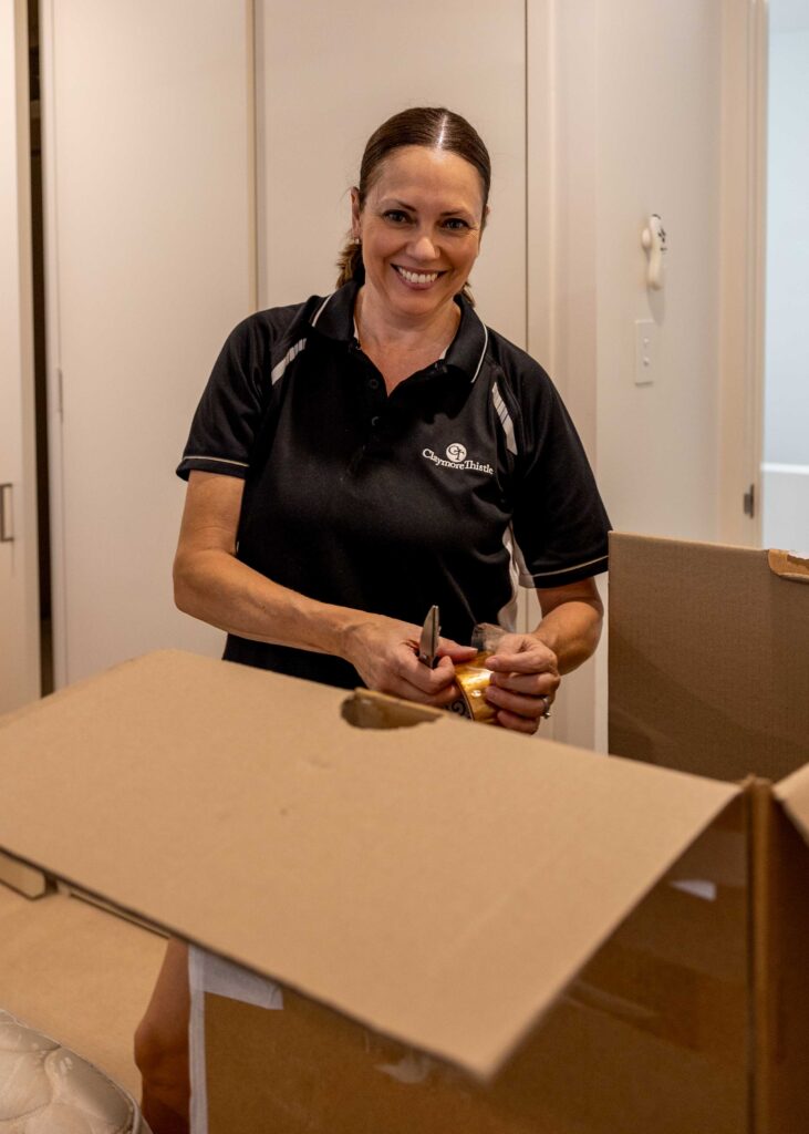 Claymore Thistle move manager smiling while unpacking boxes during a senior relocation move in Australia