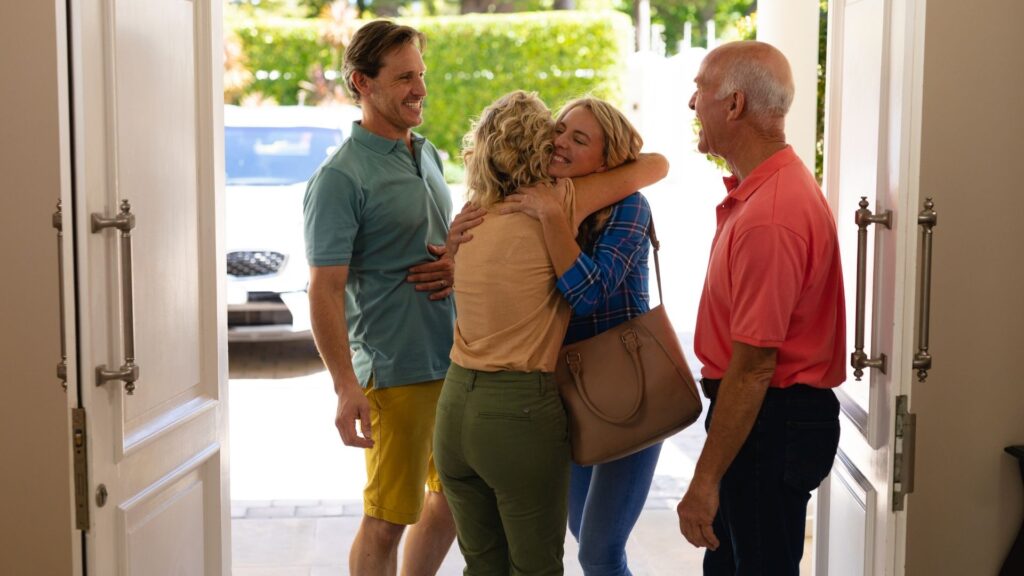 Family hugging at the doorway during goodbyes before moving to Australia from the US.